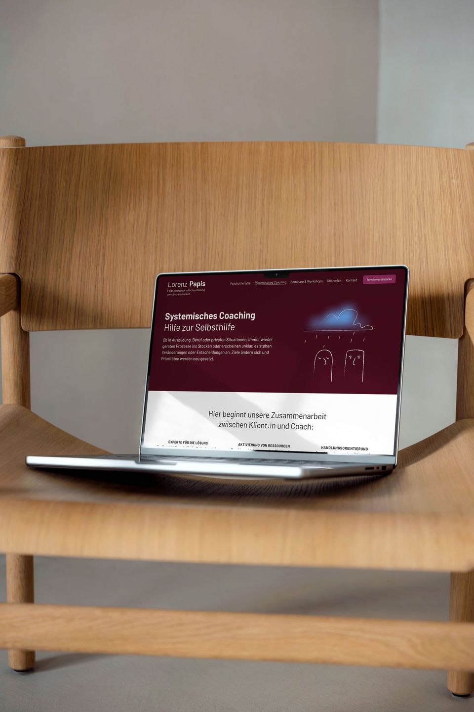 Laptop auf einem Holzstuhl mit der Webseite von Lorenz Papis